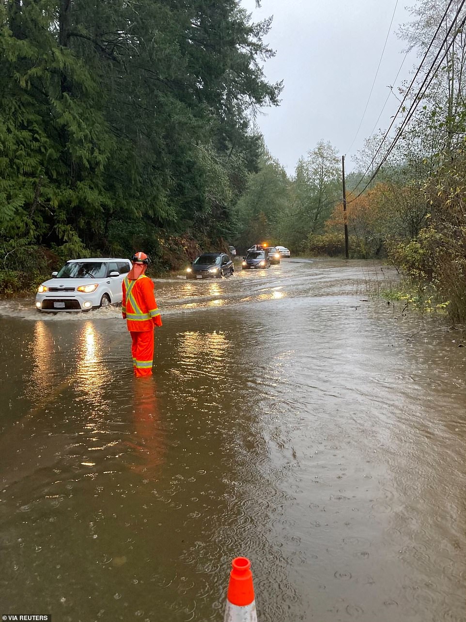 Хорошо сейчас в Колумбии! Особенно в Британской. Emergency services personnel wade through floodwaters along a damaged road in Malahat, British Columbia, Canada