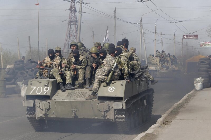 И снова - Краматорск. Фотохроника... Combat vehicles with gunmen on top make their way through a check-point to the town of Slovyansk on Wednesday, April 16, 2014. The troops on those vehicles wore green camouflage uniforms, had automatic weapons and grenade launchers and at least one had th
