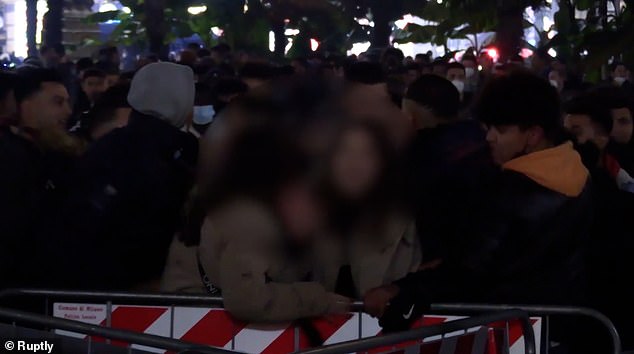 Horrific footage has emerged of New Year's Eve celebrations in Milan which saw sex attacks on at least nine women.Â In the video (pictured) two women are shown being mobbed by a group of men against security barriers in front of the square's cathedral