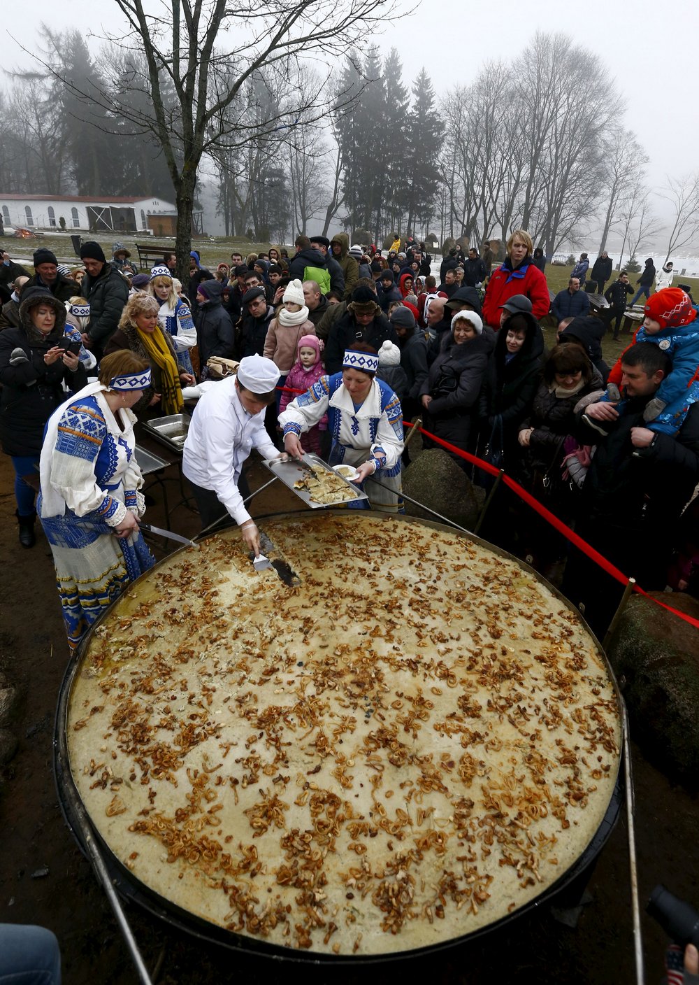 Самый большой драник в мире Employees cut fried dranik, a potato pancake that is the national dish of Belarus, to entertain visitors in the Sula History Park near the village of Sula